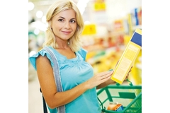 Image Woman shopping in a grocery store reading a product label